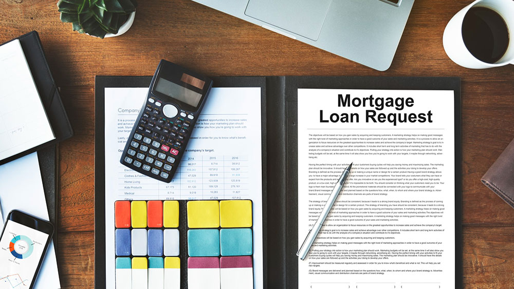FHA vs. Conventional Loans: Which Mortgage is Right for You? Mortgage Loan Request paperwork on desk with calculator and other documents